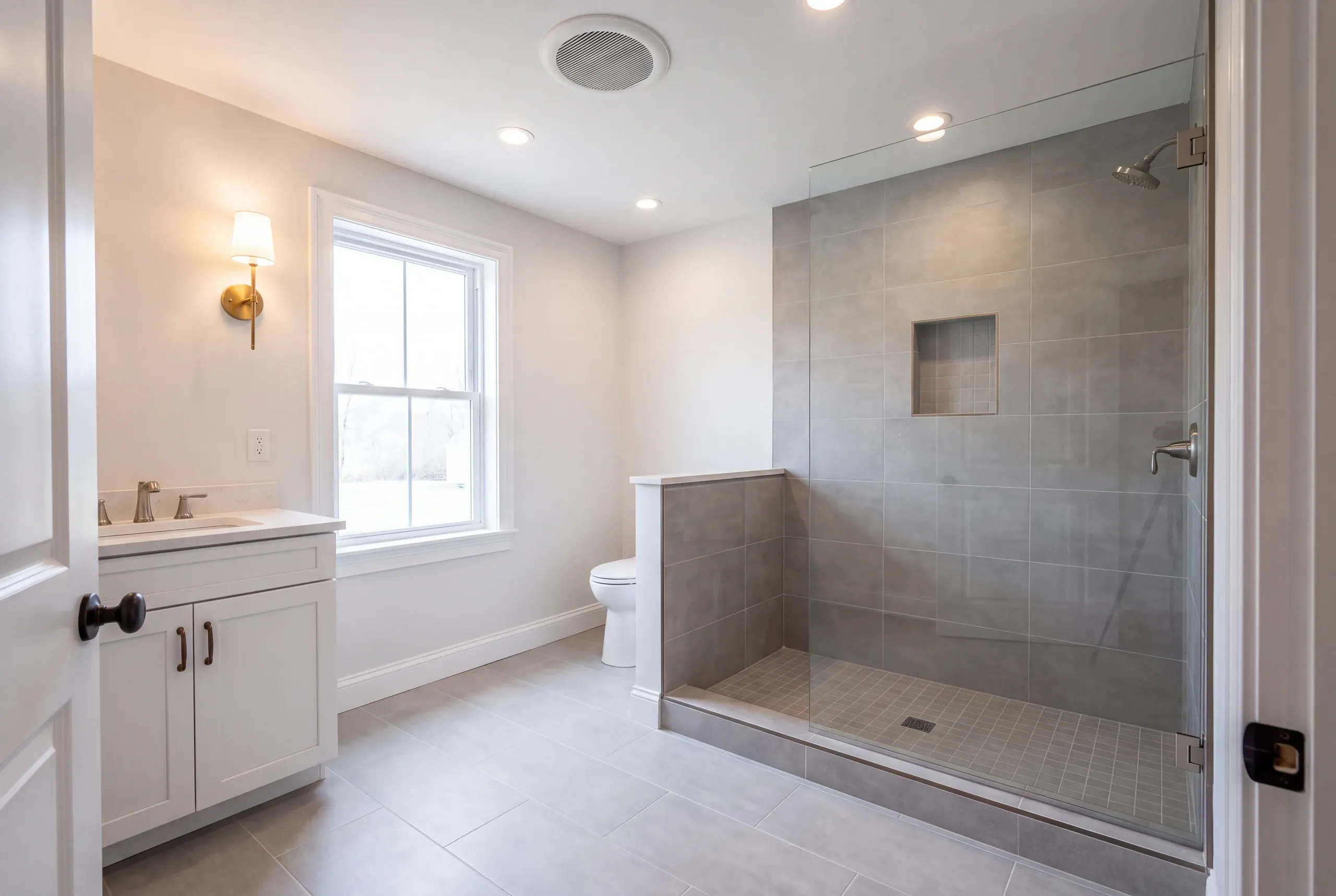 Cost to remodel a bathroom in Augusta, ME: finished bathroom with a tiled walk-in glass shower and white vanity